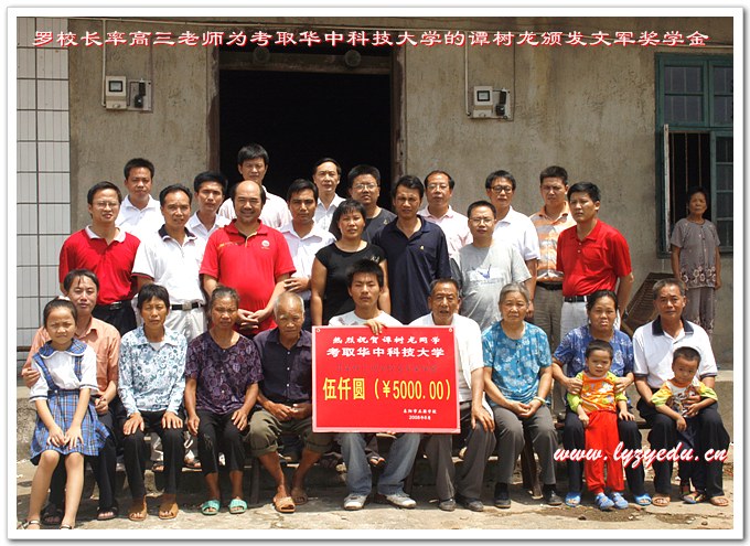 罗校长为考取华中科技大学的谭树龙同学颁发文军奖学金5000元